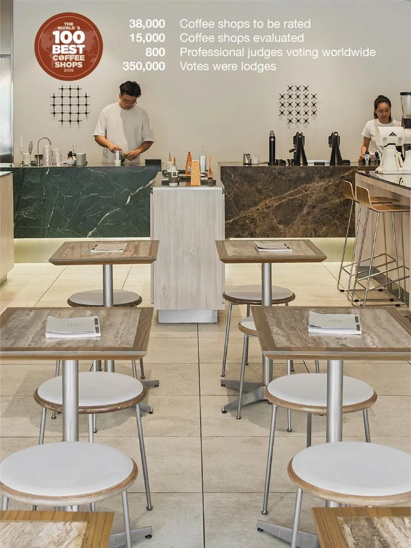 Interior shot showcasing tables and staff preparing coffee.