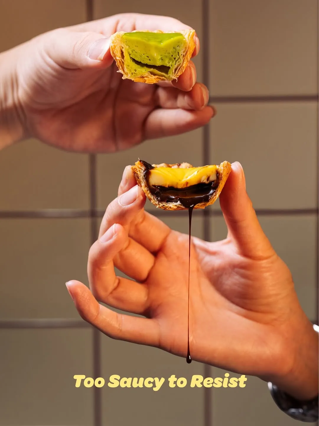 Two hands holding a split pastry with dripping filling.