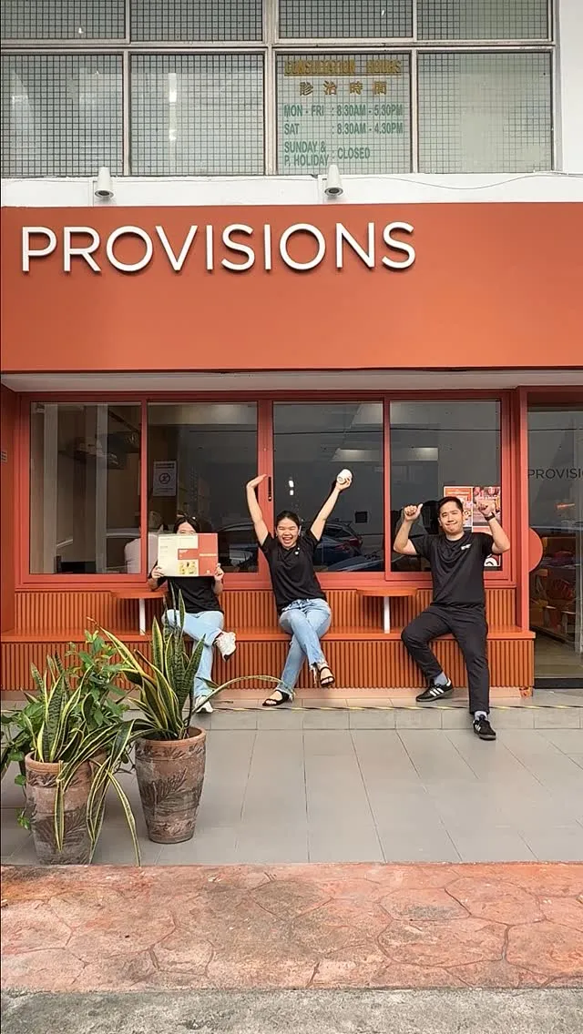 Bright cafe entrance with staff celebrating and welcoming customers back.