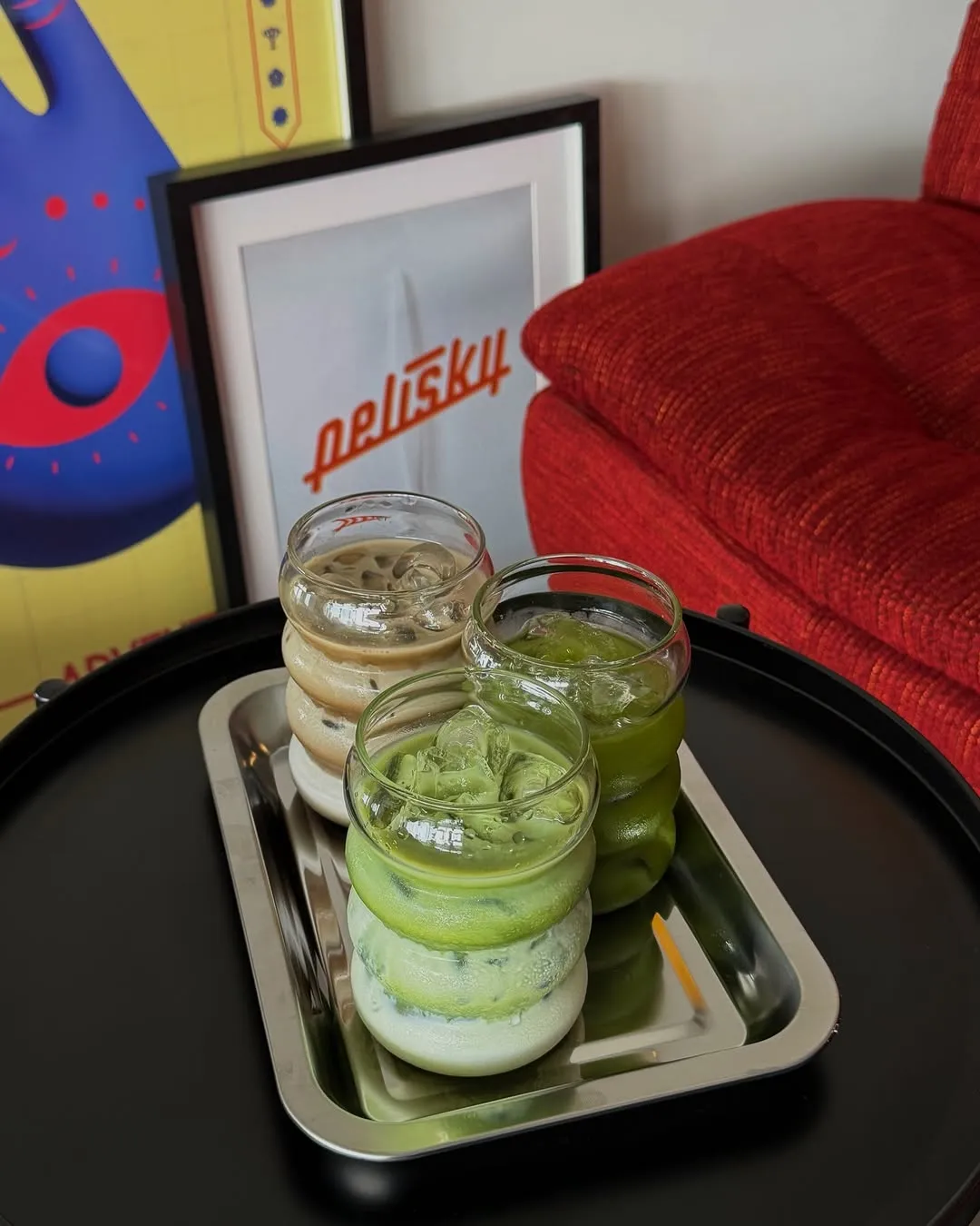 Three layered drinks on a tray, showcasing vibrant colors and textures.