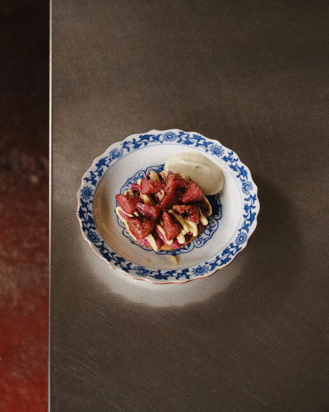 Sable tart topped with figs, lime curd, and sabayon on a patterned plate.
