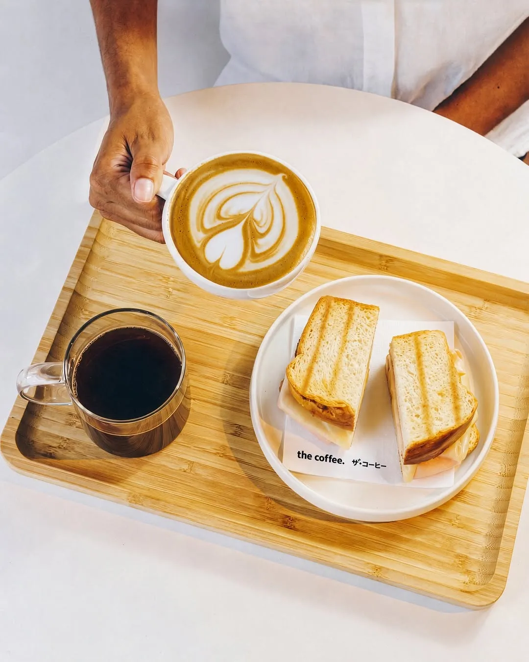 Vanilla latte paired with a grilled chicken sandwich and drip coffee.