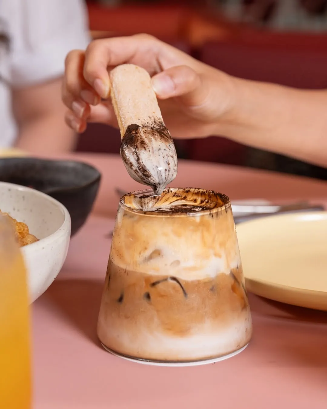 Tiramisu Coffee with a spoon being dipped into the creamy dessert layer.