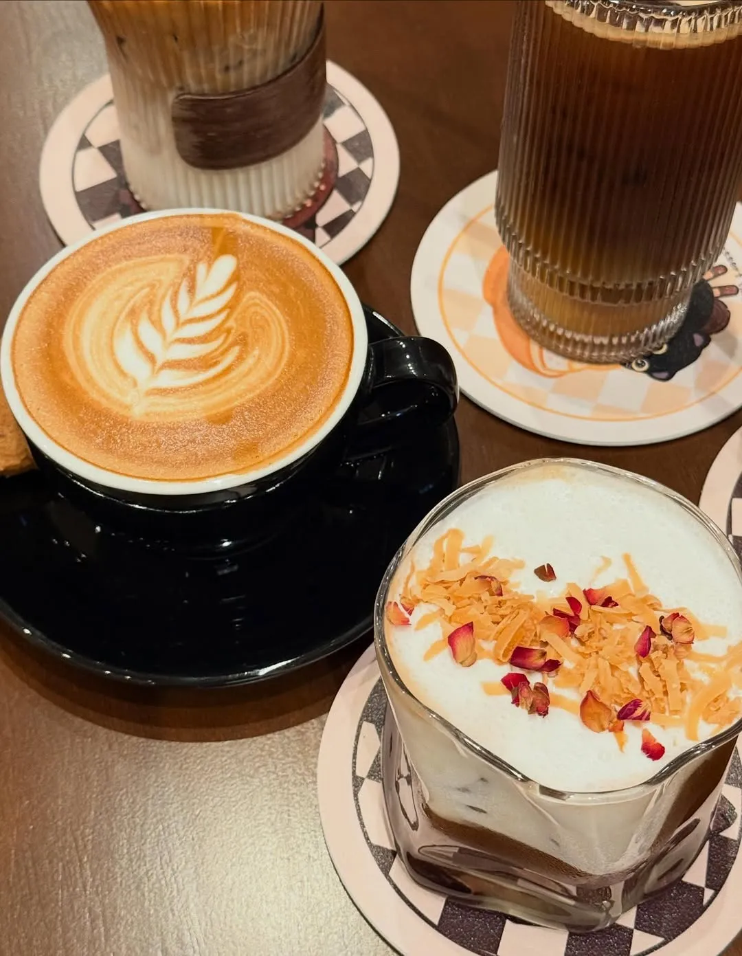 Variety of drinks including lattes and iced coffee on stylish coasters.