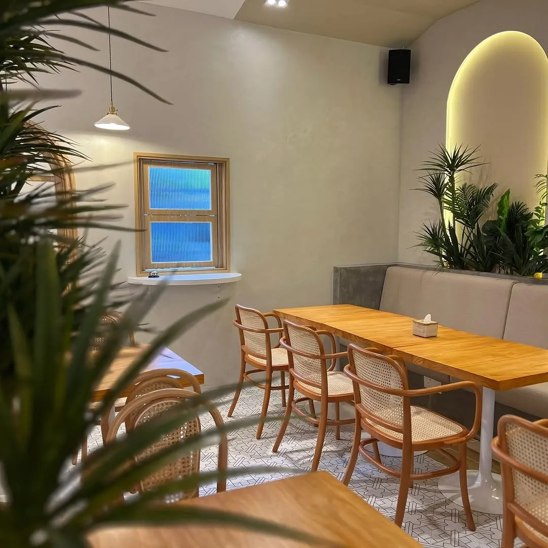 Cozy cafe interior with warm lighting and seating arrangements.