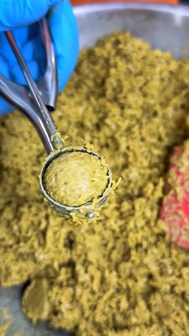 Scoop of vibrant pistachio blend ready for baking.