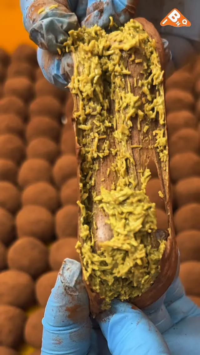 Close-up of a thick, chewy cookie with pistachio filling.
