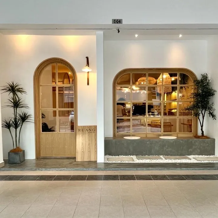 Inviting entrance with plants and wooden decor at the cafe.