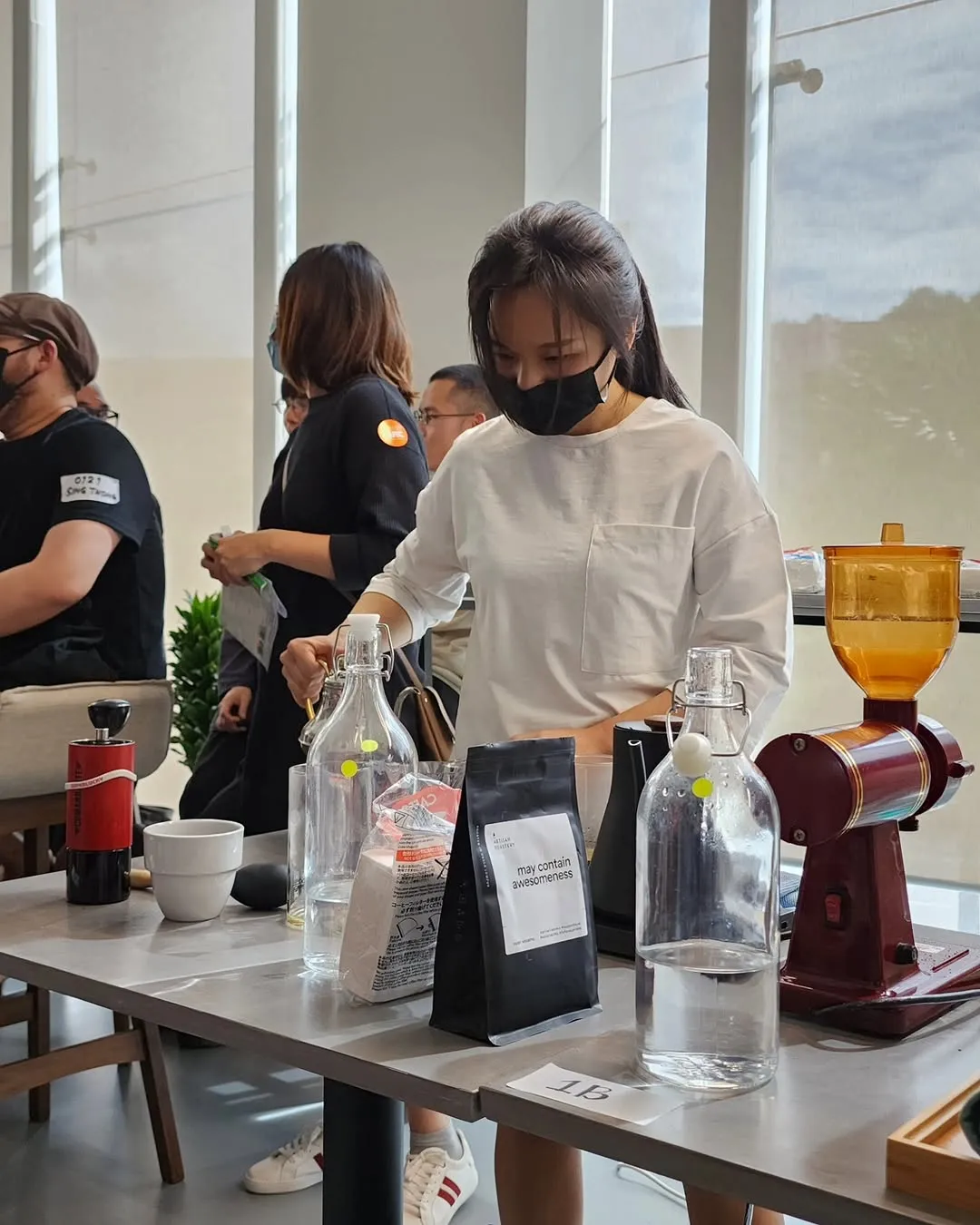 Barista preparing coffee with specialty brewing equipment on a table.