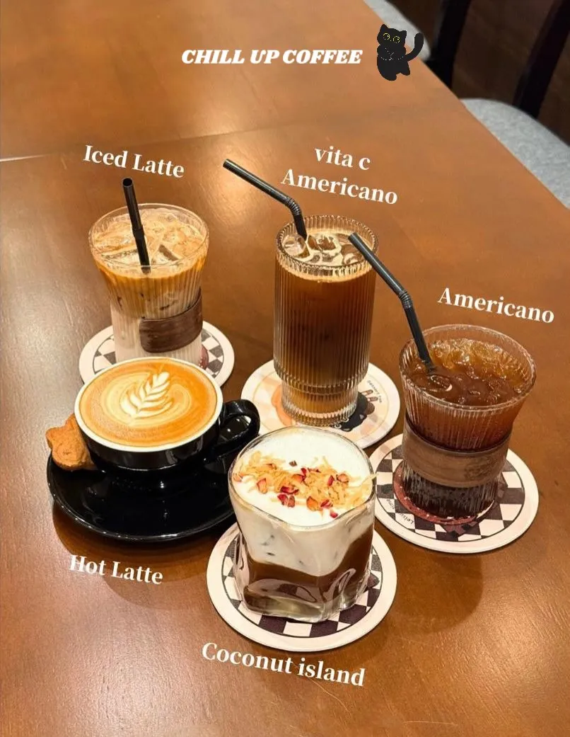 Latte art on a coffee cup next to a coconut dessert in a glass.