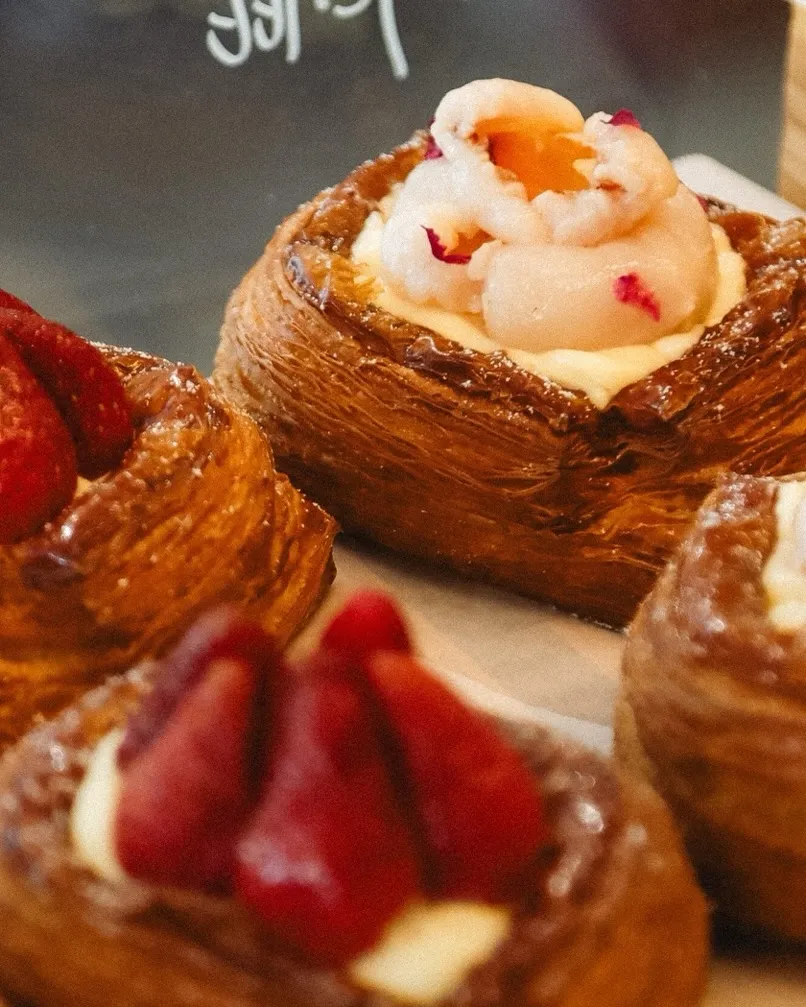 Pastries topped with strawberries and cream, showcasing delicate textures and rich colors.