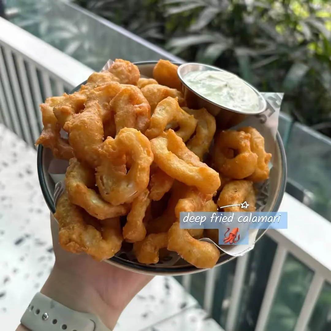 Serving of Deep Fried Calamari with a side of dipping sauce.