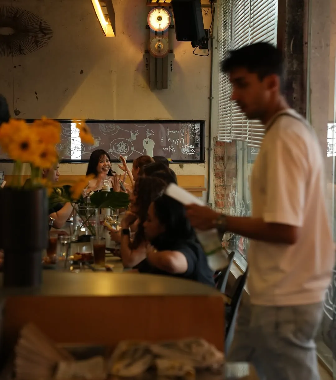 Cozy cafe scene with guests enjoying desserts and drinks indoors.