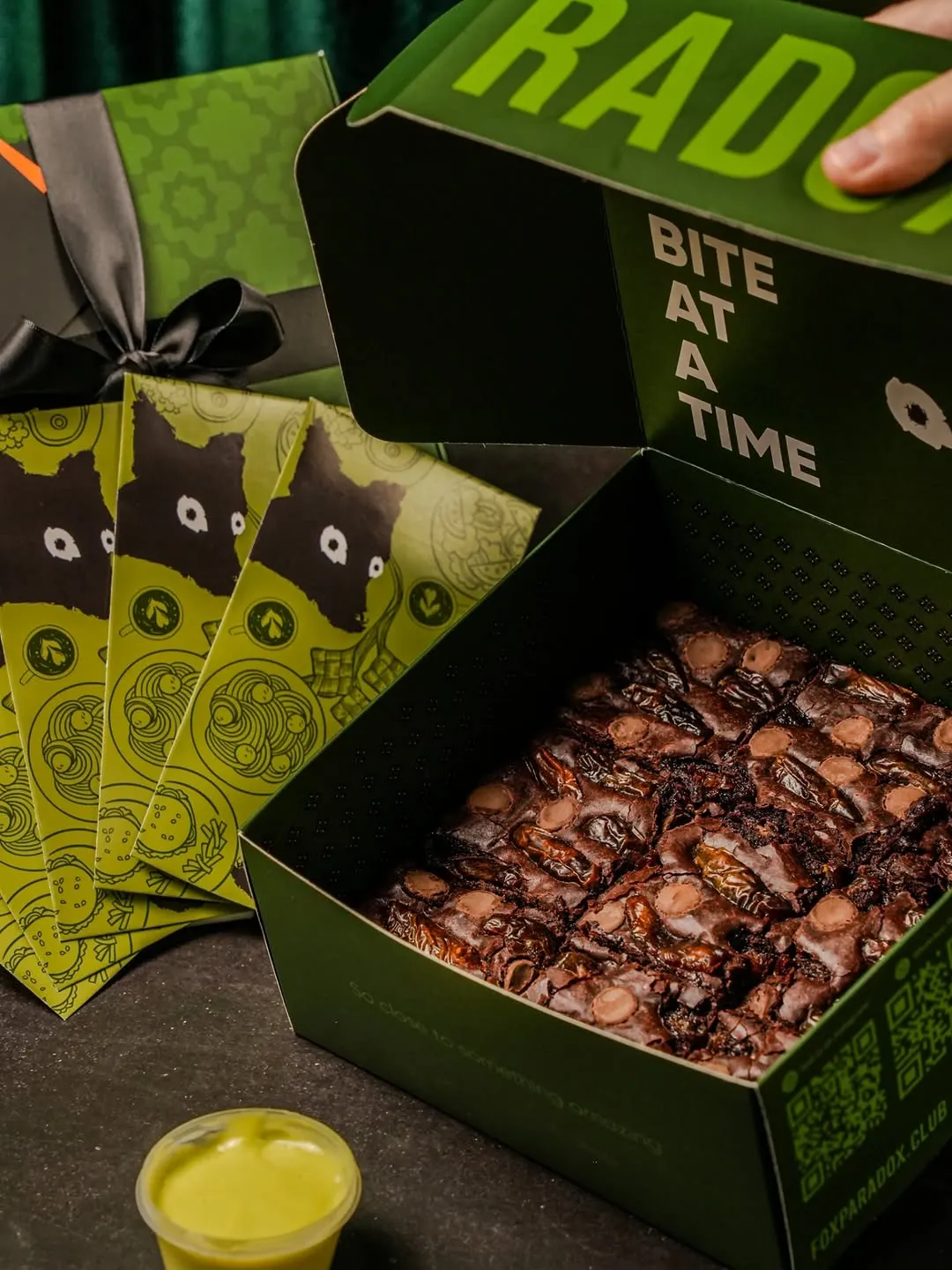 Box of brownies displayed with artistic wrapping and kaya sauce.