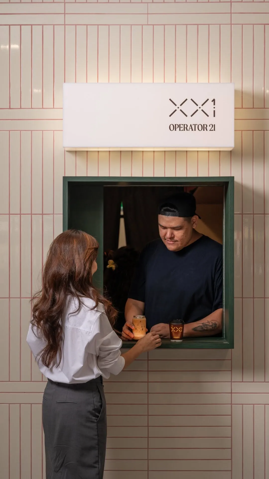 Café scene showing a staff member handing coffee through a vibrant serving window.