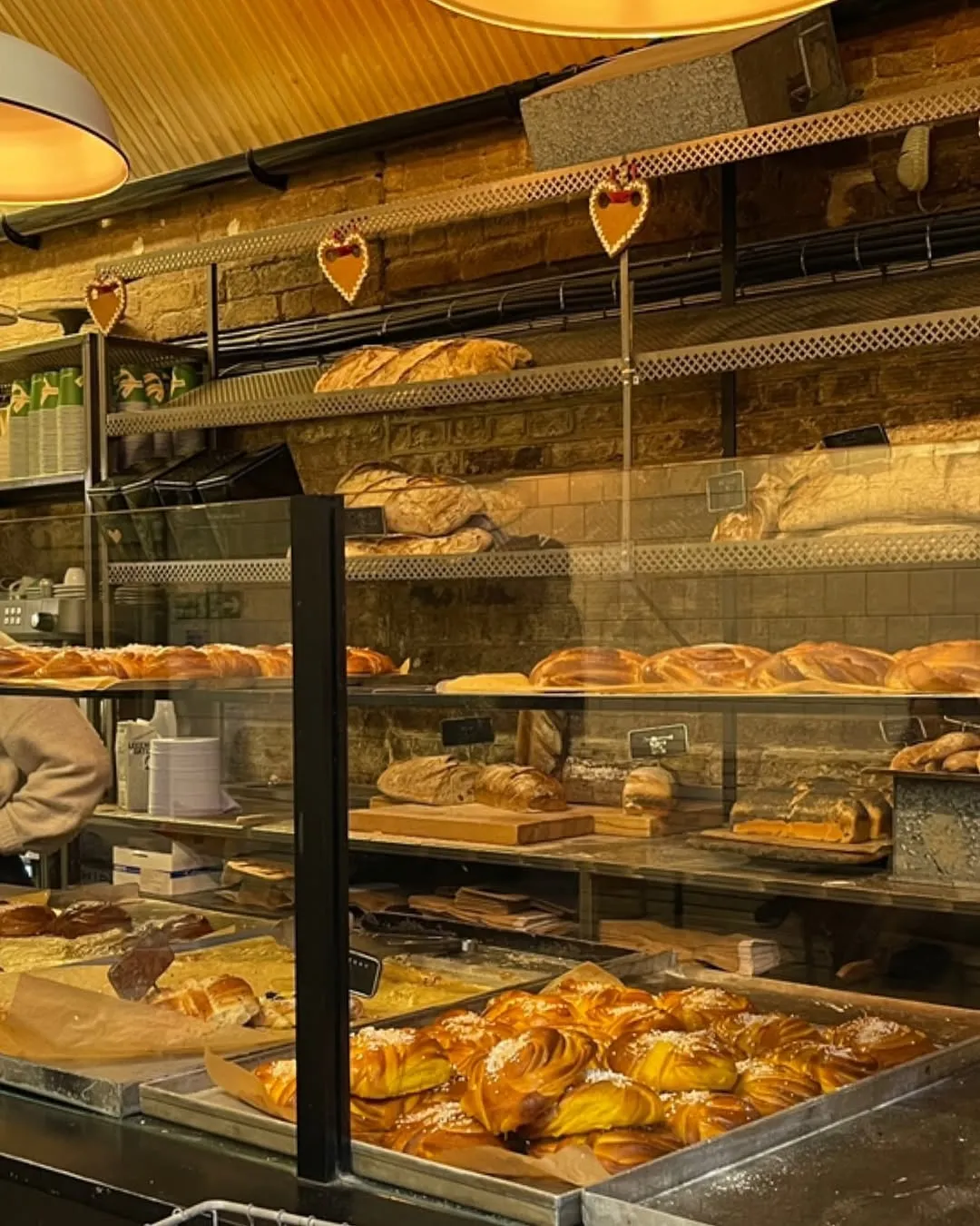 Display of freshly baked breads and pastries on shelves.