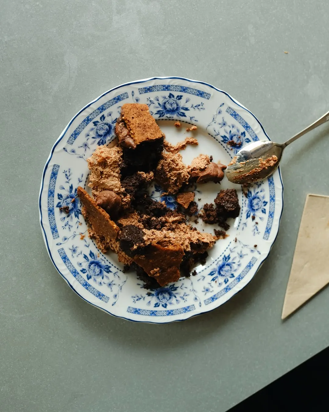 Partially eaten chocolate mousse dessert on a delicately patterned plate.