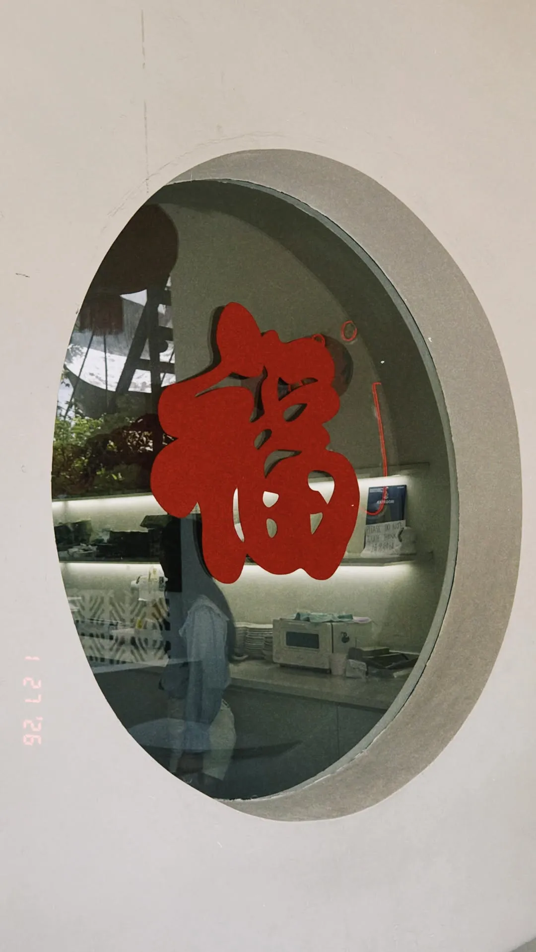 Red festive character displayed in a circular glass window.