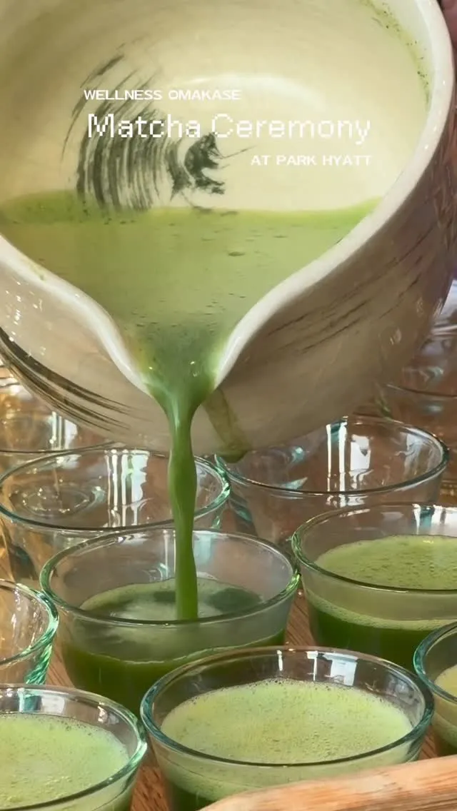 Pouring matcha tea during a ceremonial event with multiple glasses.