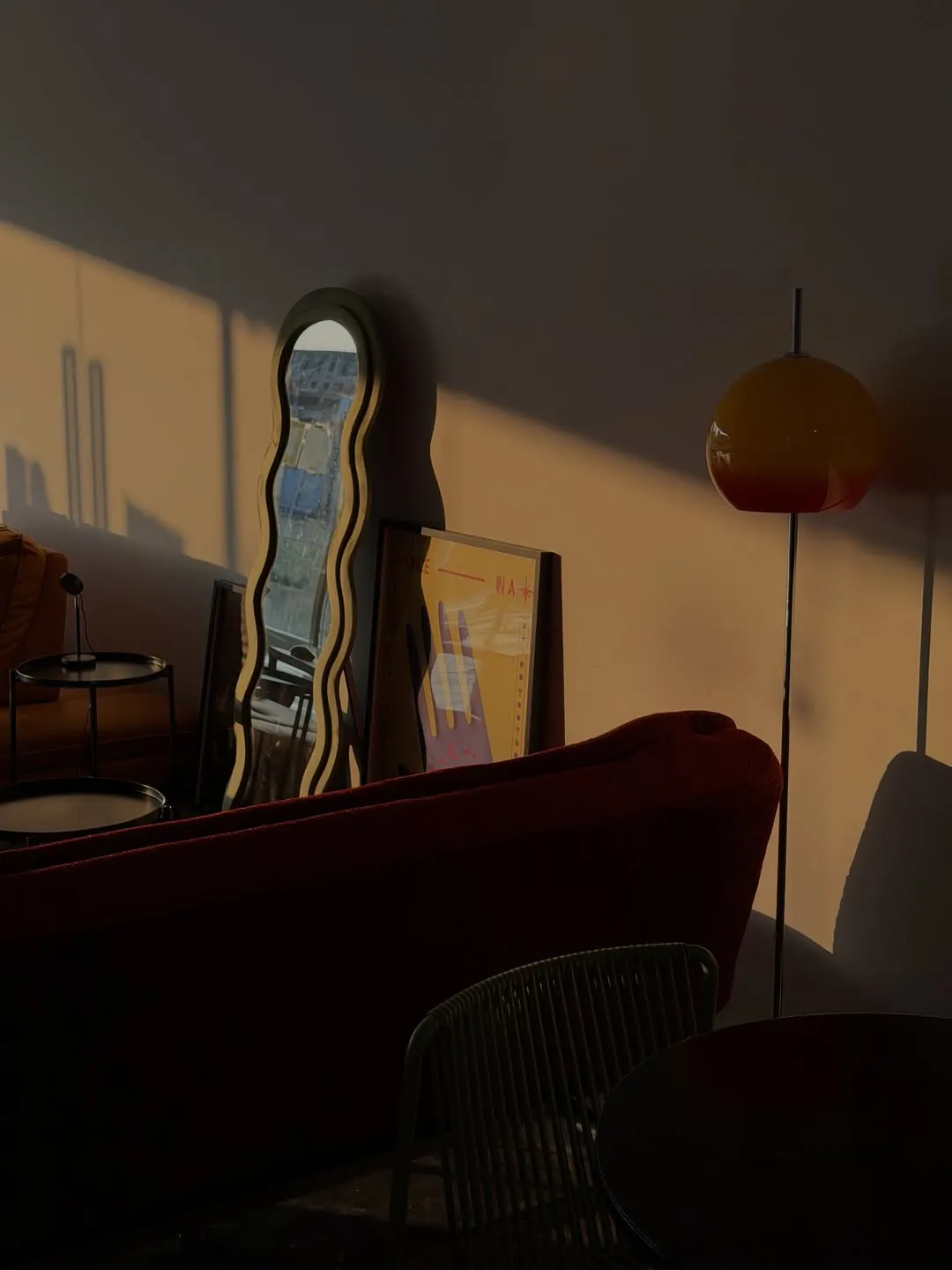 Stylish cafe interior with warm sunlight, mirrors, and colorful decor.