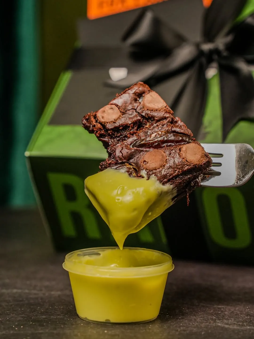 Fork lifting a brownie with kaya dipping sauce.