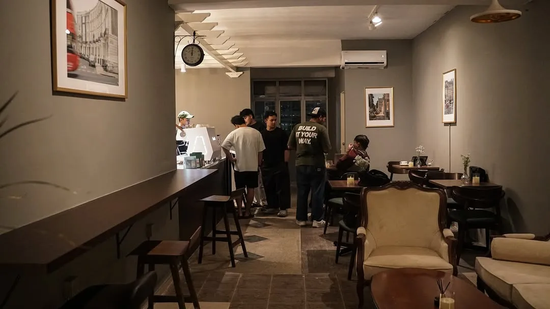 Customers interacting at a bar-style counter in a chic cafe setting.