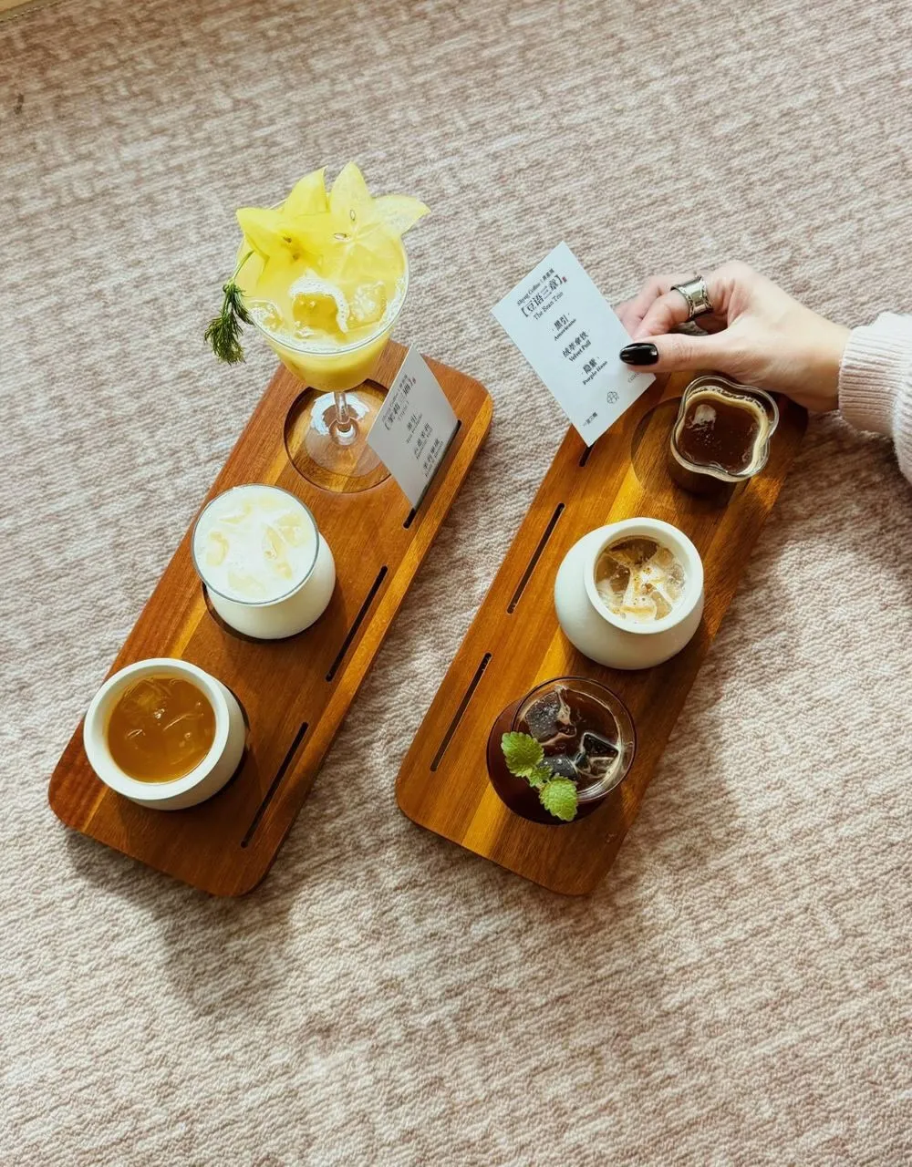 A wooden board displays various drinks with tasting notes in small cards.