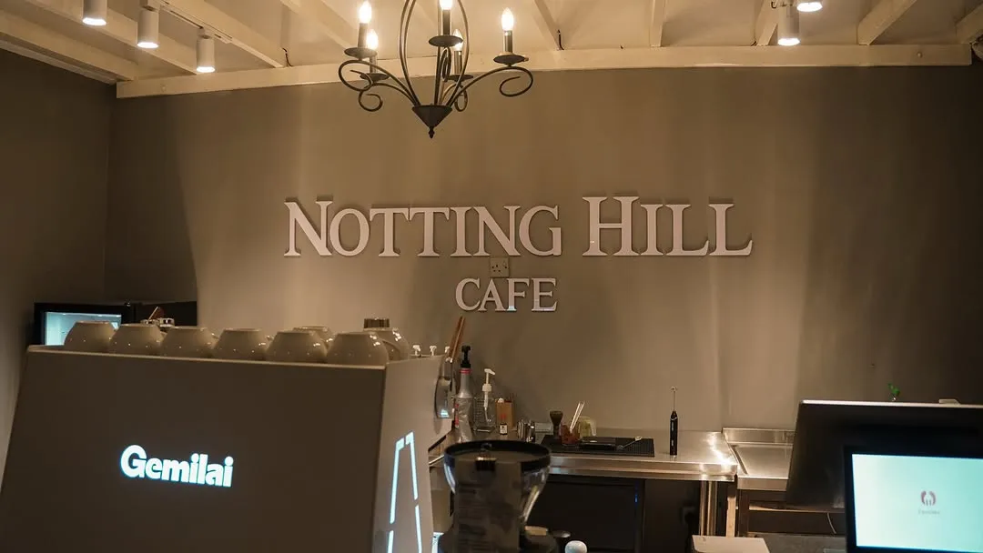 Elegant cafe signage with a stylish barista counter and decorative chandelier.