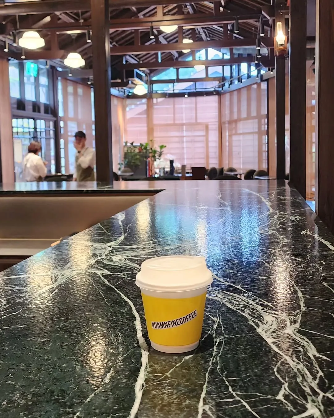 Brightly colored takeaway coffee cup on a marble countertop.
